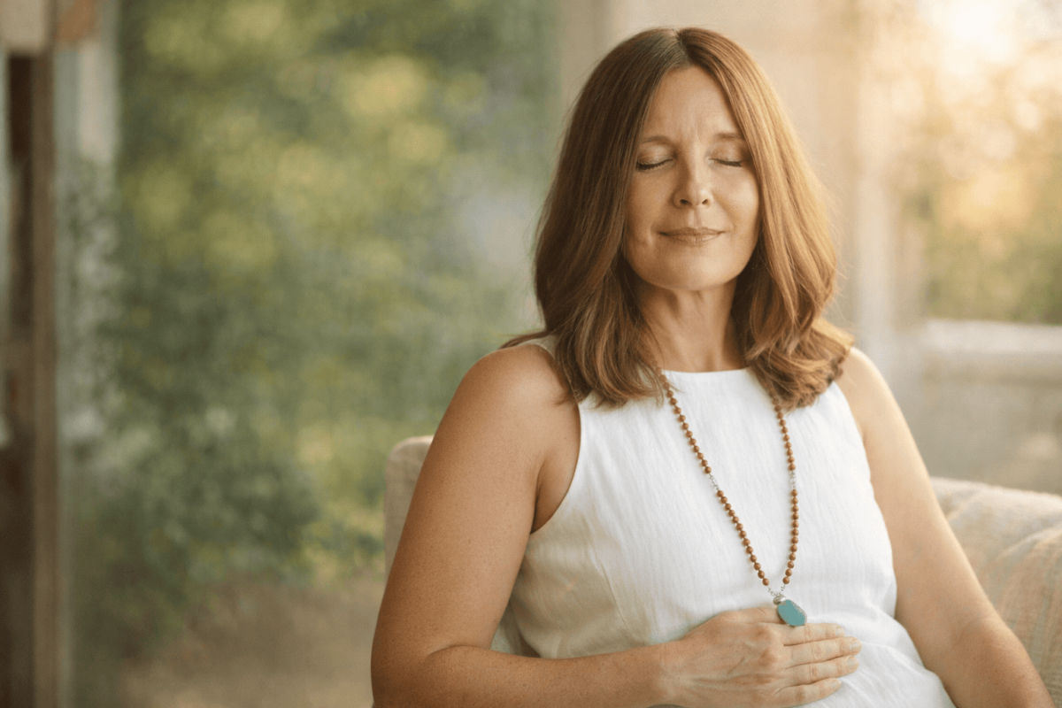 Frau in Diegten praktiziert Atem-Heilkraft zur Entspannung des Nervensystems.