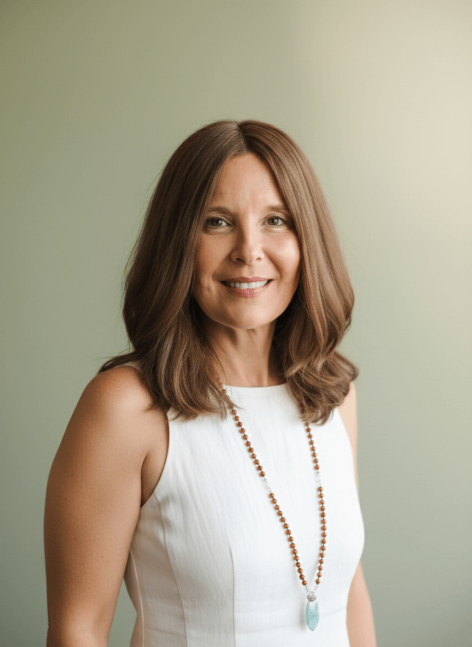 Portrait von Sandra, einer freundlich lächelnden Frau mit braunen Haaren und weisser Bluse vor einem sanft grünen Hintergrund.